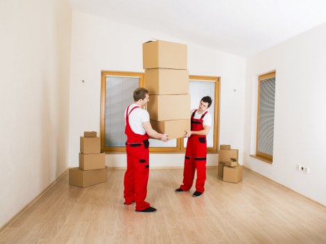 Professional movers carrying furniture in a Wapping apartment building